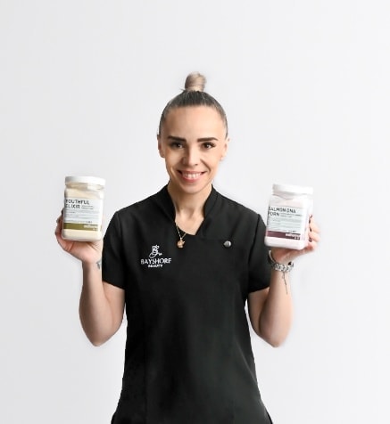 Bayshore Beauty esthetician holding skincare products