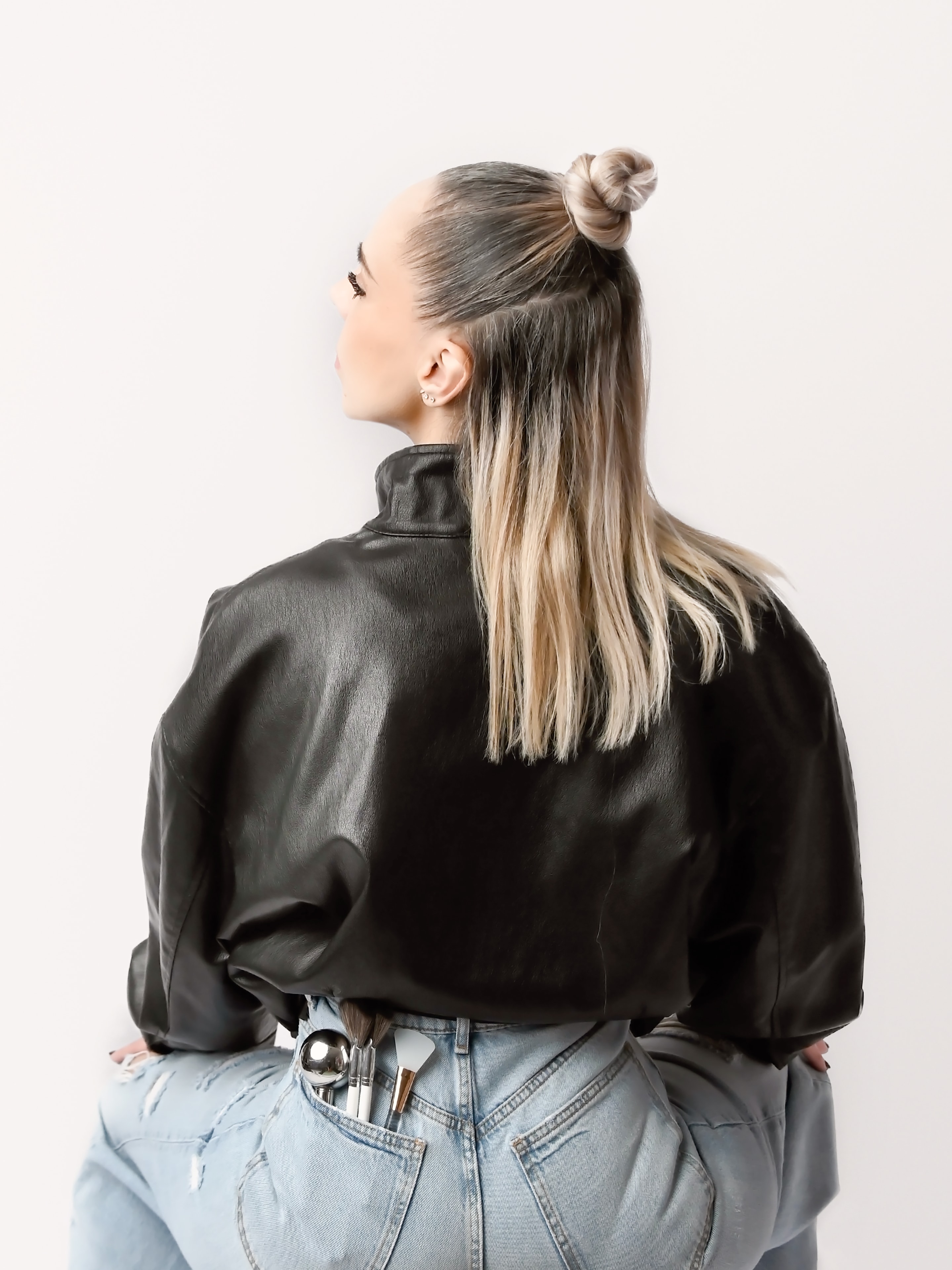 Victoria with makeup brushes tucked in her jeans, editorial portrait